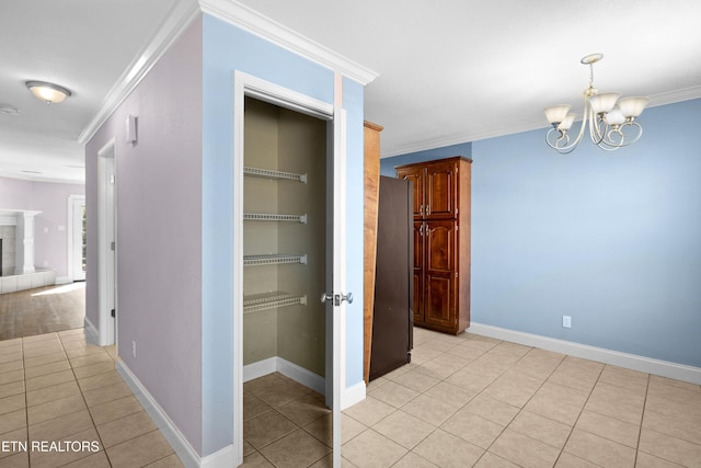 corridor featuring ornamental molding, light tile patterned flooring, a notable chandelier, and baseboards