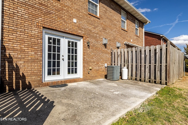 view of patio featuring central AC unit, fence, and french doors