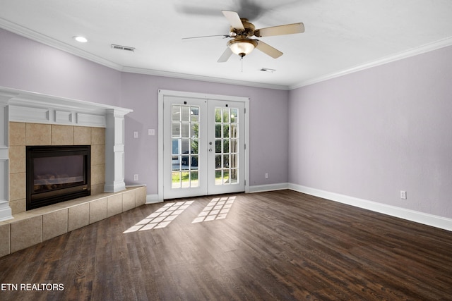 unfurnished living room featuring wood finished floors, visible vents, baseboards, ornamental molding, and a tiled fireplace