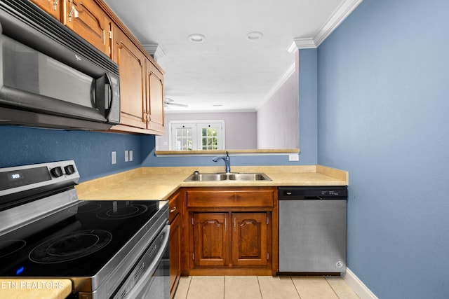 kitchen with light countertops, appliances with stainless steel finishes, brown cabinetry, ornamental molding, and a sink