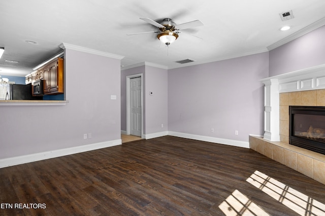 unfurnished living room featuring crown molding, visible vents, wood finished floors, and a tile fireplace