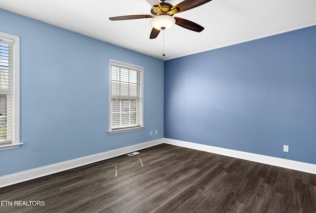 spare room featuring ceiling fan, baseboards, and dark wood-style flooring