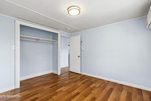 unfurnished bedroom featuring a closet, baseboards, and wood finished floors