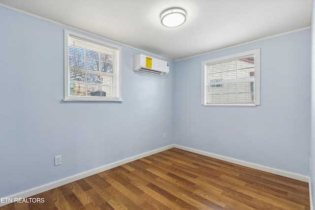 empty room with plenty of natural light, dark wood-type flooring, a wall unit AC, and baseboards