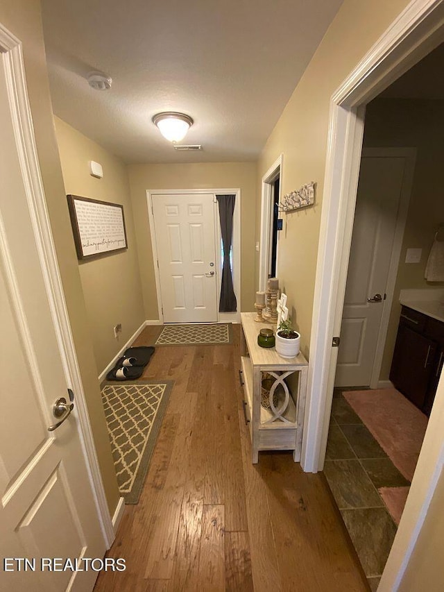 interior space featuring wood finished floors, visible vents, and baseboards