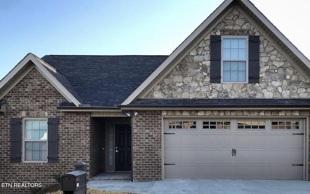 view of front of property featuring a garage, stone siding, brick siding, and a shingled roof