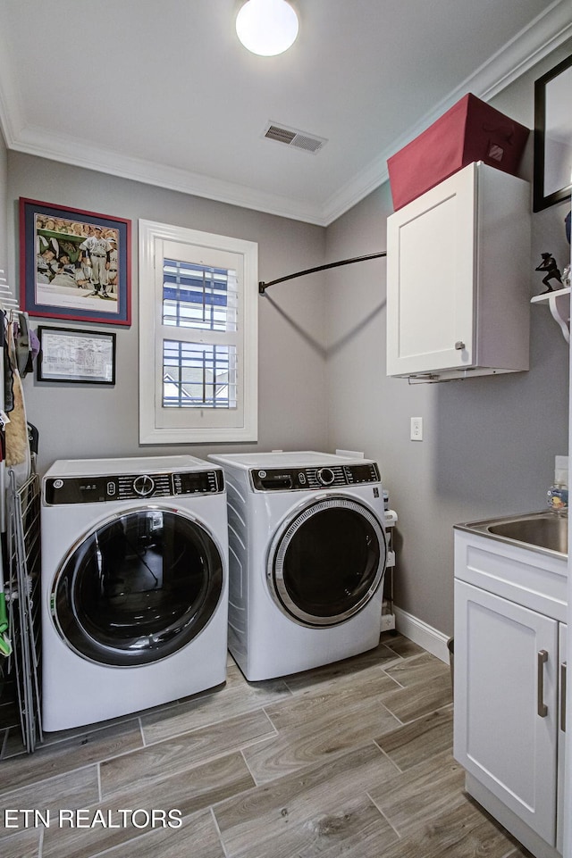 laundry room with cabinet space, visible vents, ornamental molding, independent washer and dryer, and wood tiled floor