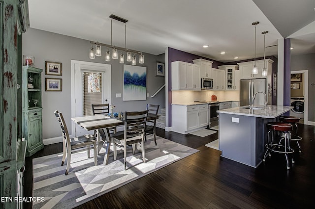 dining area with dark wood-style floors, recessed lighting, washer / dryer, and baseboards