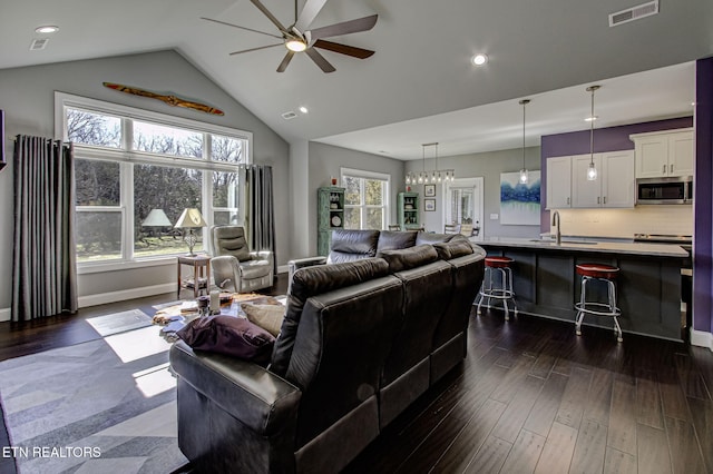 living room featuring ceiling fan, dark wood finished floors, visible vents, and a healthy amount of sunlight