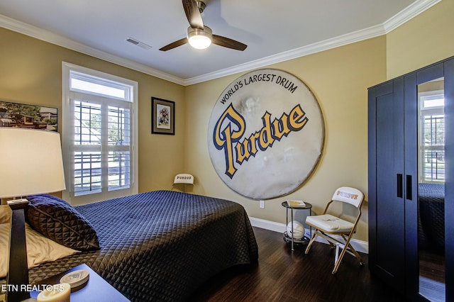 bedroom with dark wood-style flooring, visible vents, ornamental molding, a ceiling fan, and baseboards