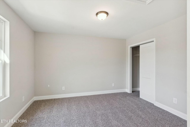 unfurnished bedroom featuring a closet, carpet flooring, and baseboards