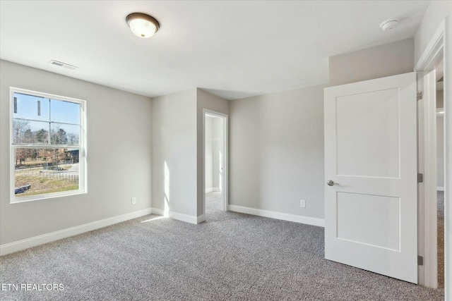 unfurnished bedroom featuring carpet flooring, visible vents, and baseboards