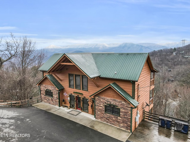 rustic home with metal roof, stone siding, and a mountain view