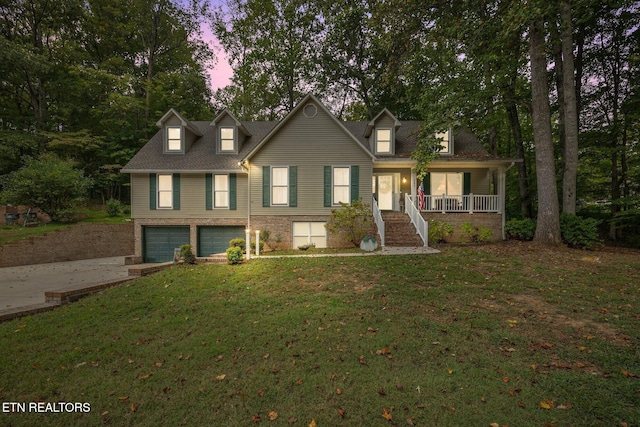 new england style home featuring driveway, an attached garage, covered porch, stairs, and a yard