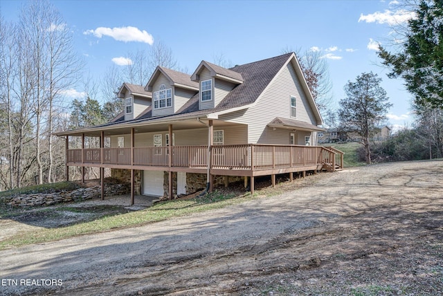 view of front of home with driveway, stone siding, and an attached garage