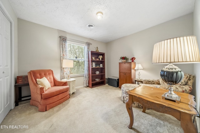 home office with a textured ceiling, carpet floors, and visible vents