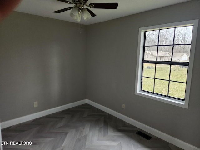 unfurnished room featuring plenty of natural light, visible vents, and baseboards