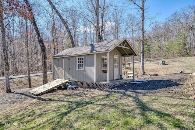 view of outbuilding featuring a wooded view and an outdoor structure