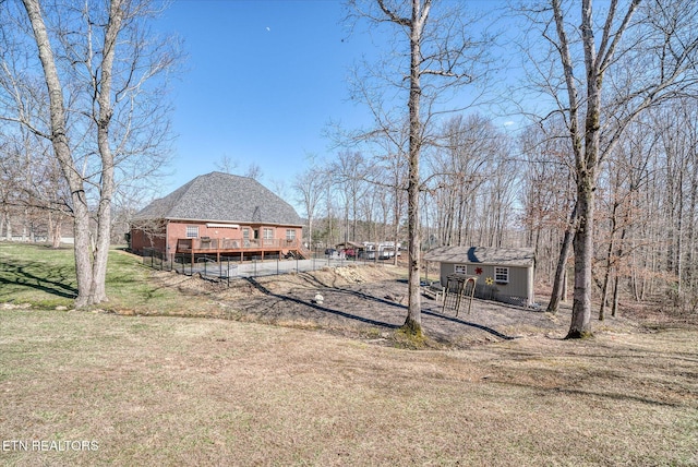 view of yard with an outbuilding, a wooden deck, and dirt driveway