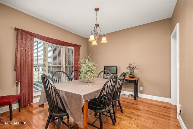 dining room with a chandelier, light wood-type flooring, and baseboards