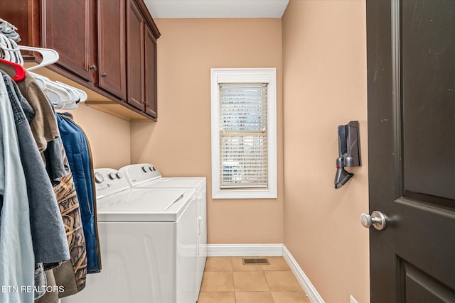 laundry area featuring cabinet space, light tile patterned floors, visible vents, baseboards, and washer and clothes dryer