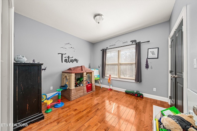 game room with hardwood / wood-style flooring and baseboards