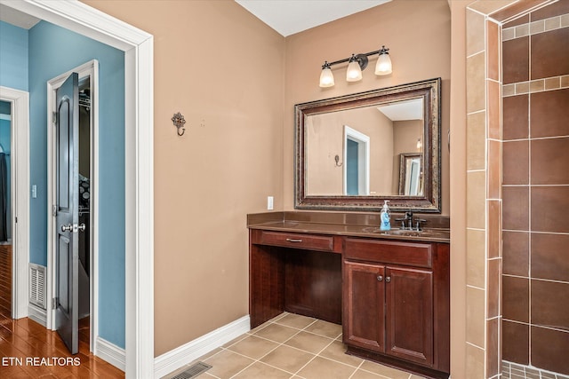 bathroom with baseboards, vanity, visible vents, and tile patterned floors