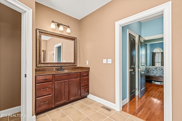 ensuite bathroom featuring visible vents, vanity, ensuite bath, baseboards, and tile patterned floors