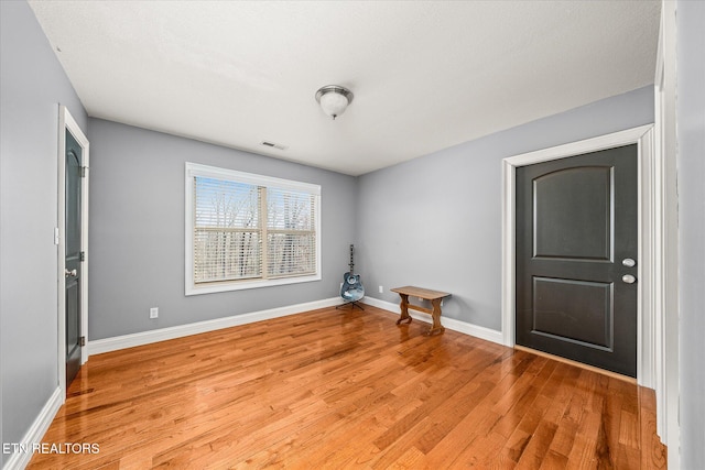 unfurnished room with light wood-type flooring, baseboards, and visible vents