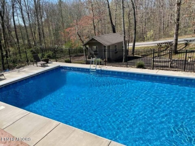 view of pool with a patio area, fence, a fenced in pool, and an outdoor structure