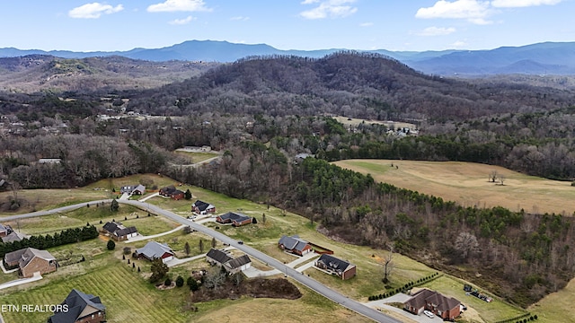 drone / aerial view with a wooded view and a mountain view