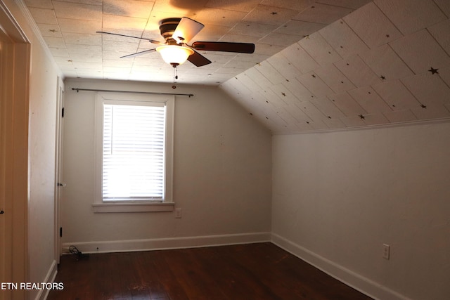 additional living space with baseboards, hardwood / wood-style floors, a ceiling fan, and vaulted ceiling