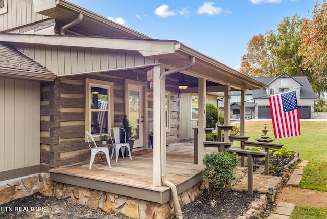 wooden terrace featuring a porch and a yard