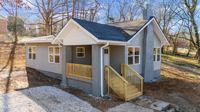 view of front of property with a chimney and roof with shingles