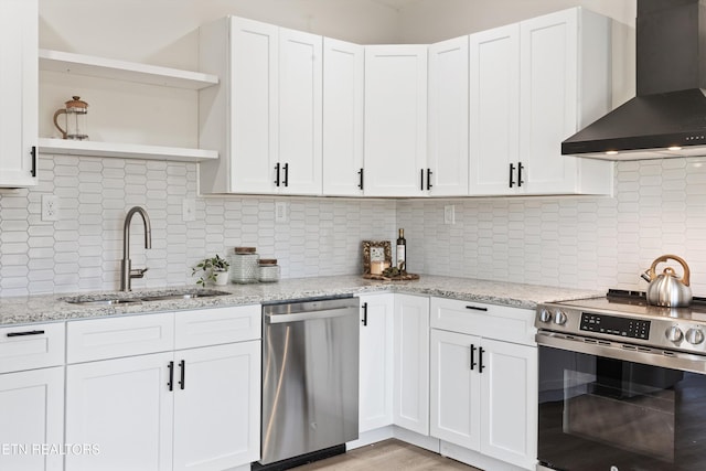 kitchen featuring white cabinets, appliances with stainless steel finishes, wall chimney range hood, open shelves, and a sink