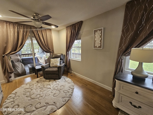 living area with ceiling fan, wood finished floors, and baseboards