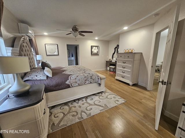 bedroom featuring baseboards, light wood-style flooring, ceiling fan, a wall mounted air conditioner, and recessed lighting