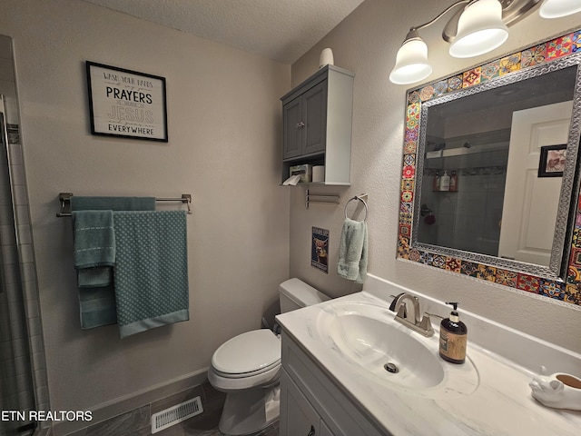 bathroom with visible vents, toilet, a tile shower, a textured ceiling, and vanity