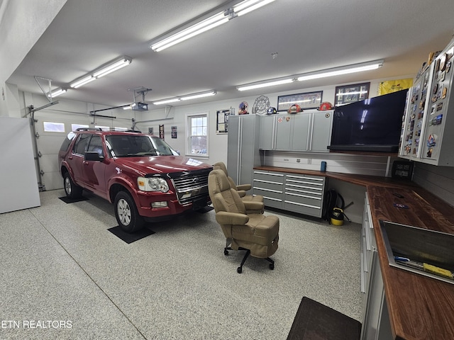 garage featuring freestanding refrigerator and a garage door opener