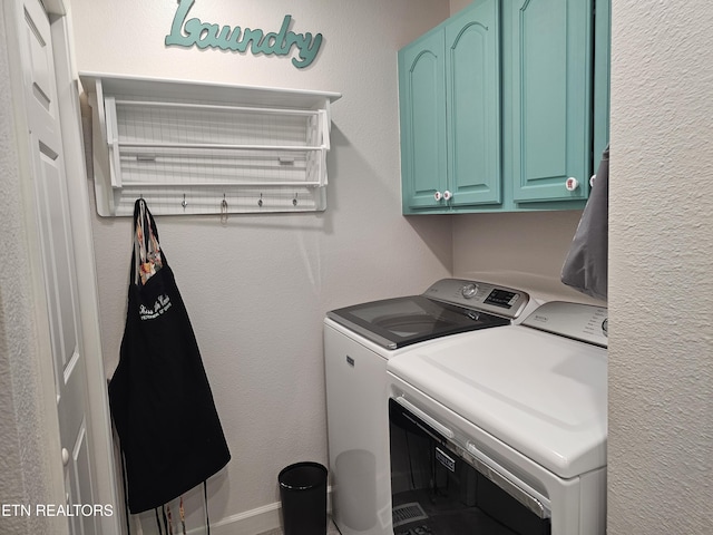 laundry room featuring a textured wall, washer and clothes dryer, and cabinet space