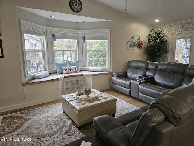 living area with baseboards, light wood finished floors, and crown molding