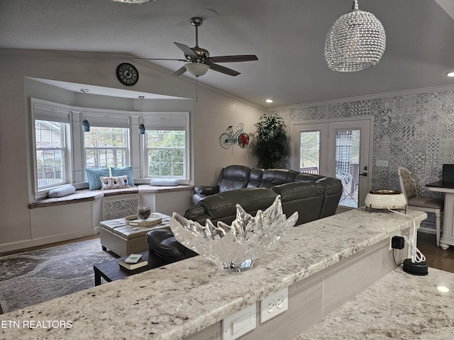 interior space with wallpapered walls, baseboards, wood finished floors, vaulted ceiling, and crown molding