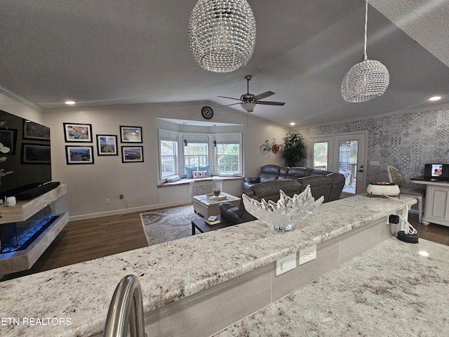 living area with baseboards, vaulted ceiling, wallpapered walls, dark wood finished floors, and crown molding