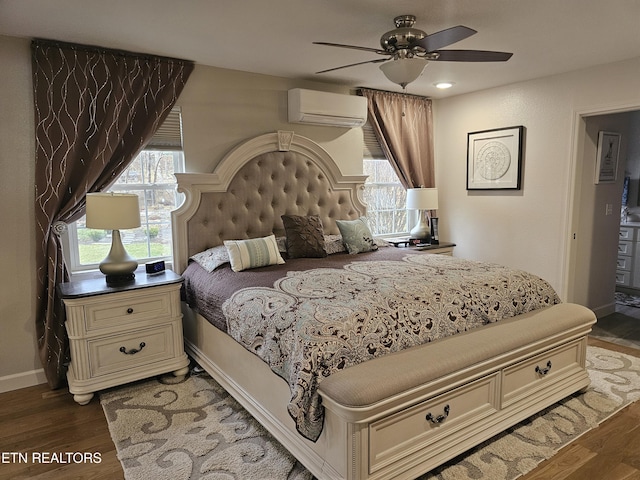 bedroom featuring wood finished floors, multiple windows, baseboards, and a wall mounted AC