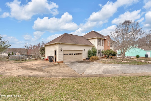 view of front facade featuring an attached garage, fence, and concrete driveway