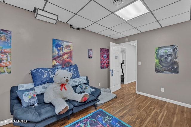 game room with a paneled ceiling, wood finished floors, visible vents, and baseboards