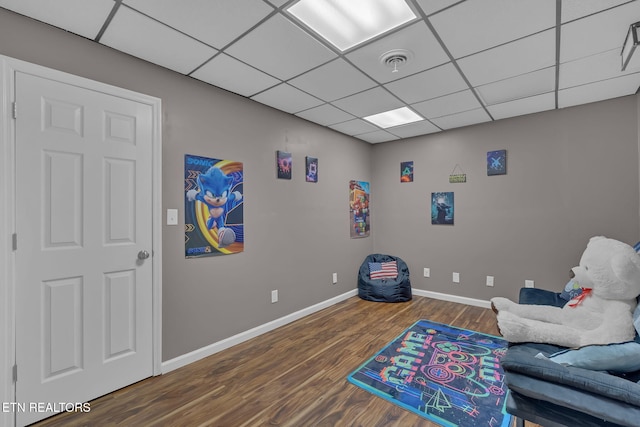 sitting room with a paneled ceiling, visible vents, baseboards, and wood finished floors