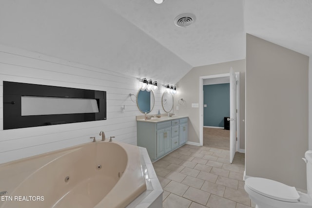 bathroom featuring lofted ceiling, toilet, visible vents, a jetted tub, and double vanity