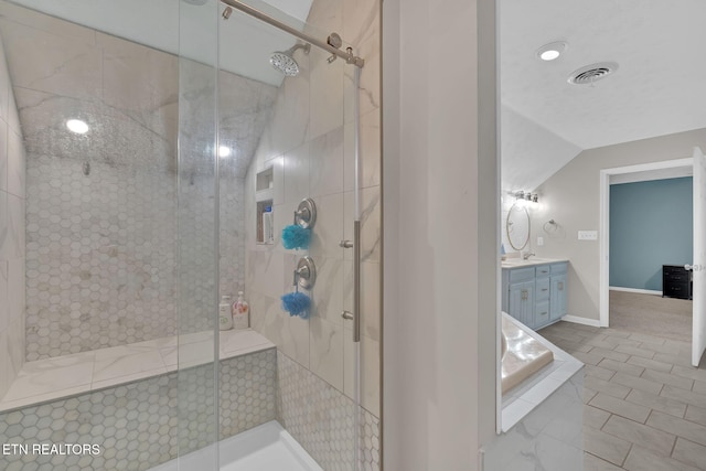 bathroom featuring visible vents, vaulted ceiling, a shower stall, and vanity