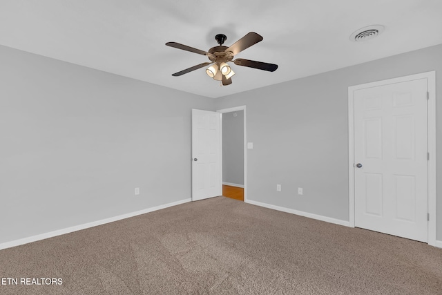 unfurnished bedroom with a ceiling fan, carpet flooring, visible vents, and baseboards